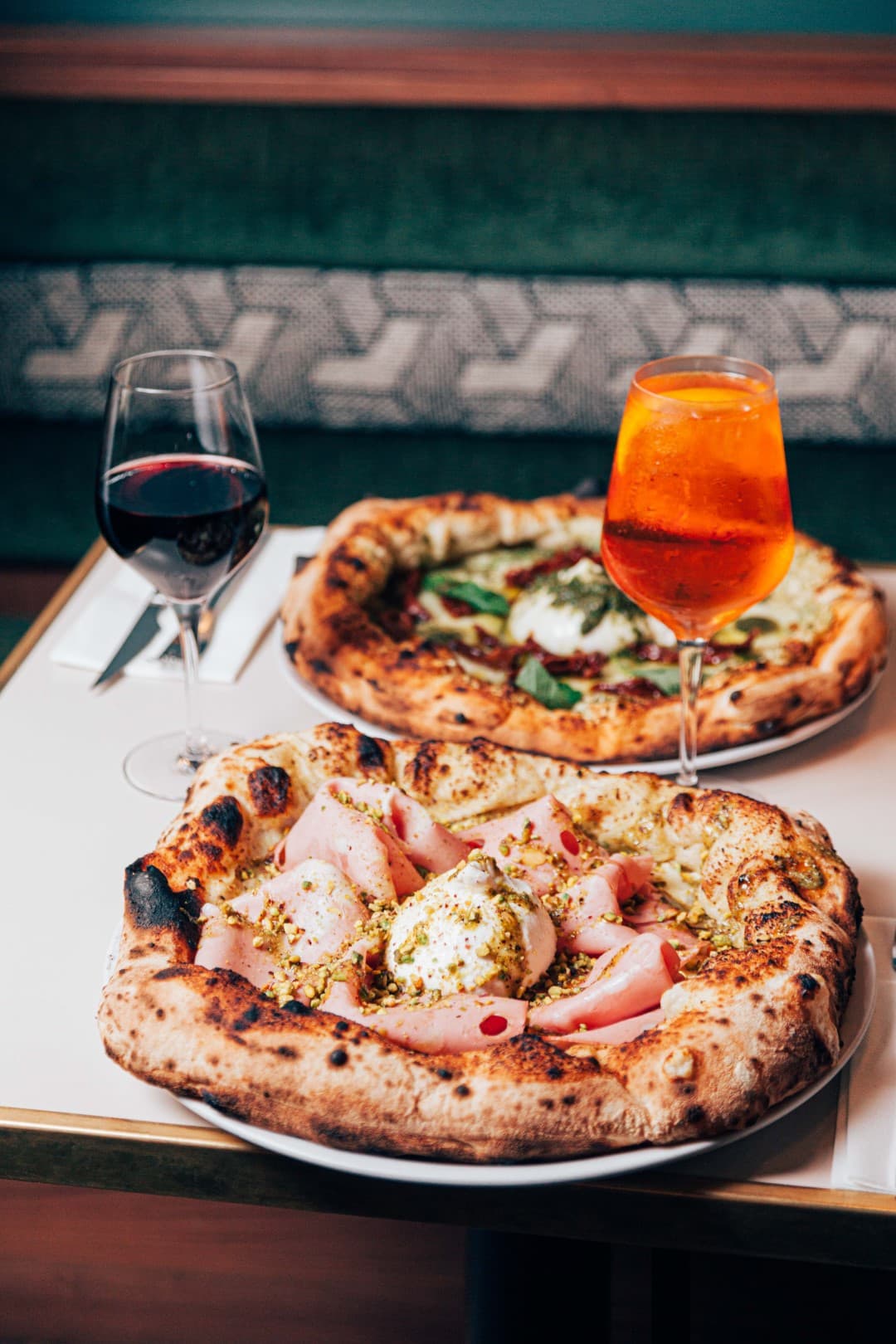 Deux pizzas Mat’izza servies à table avec une boisson italienne