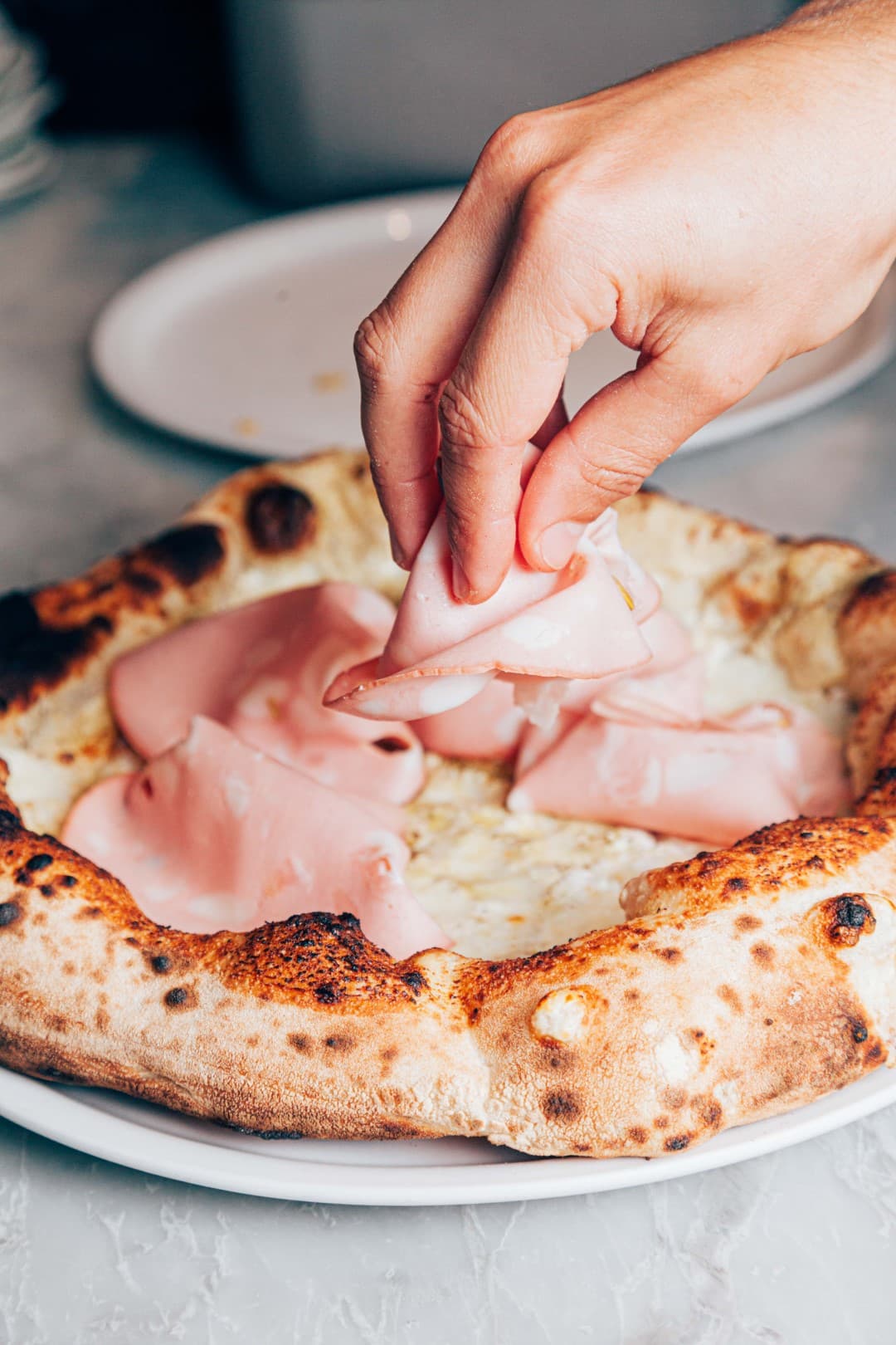 Geste de service sur une pizza Mat’izza