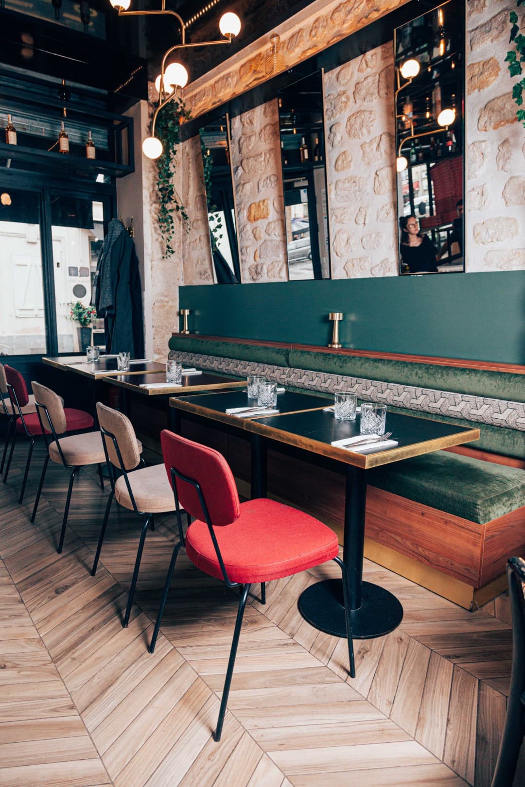 Salle de restaurant Mat’izza avec banquette verte et chaises colorées